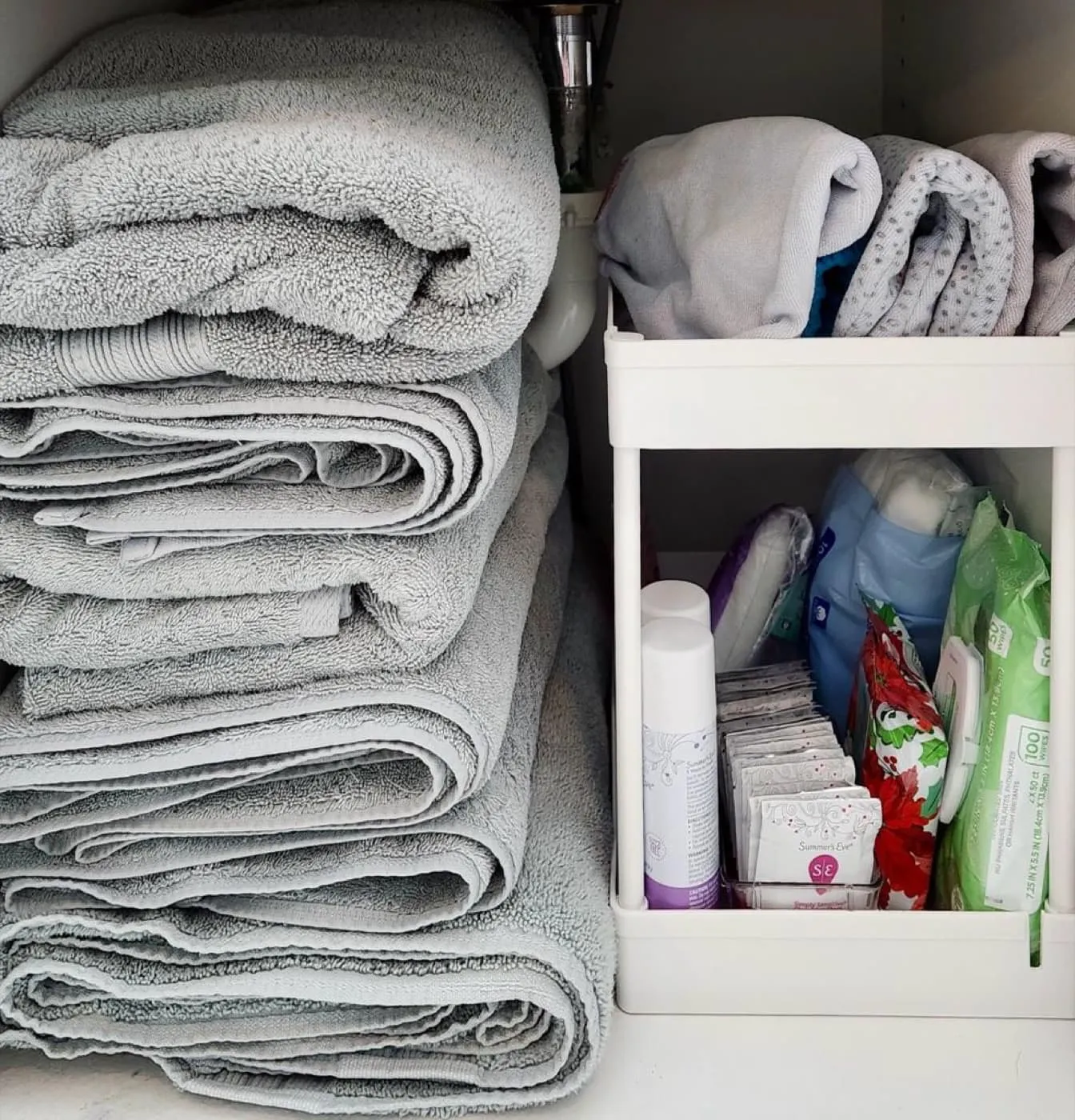 Folded towels and bathroom essentials organized inside a cabinet